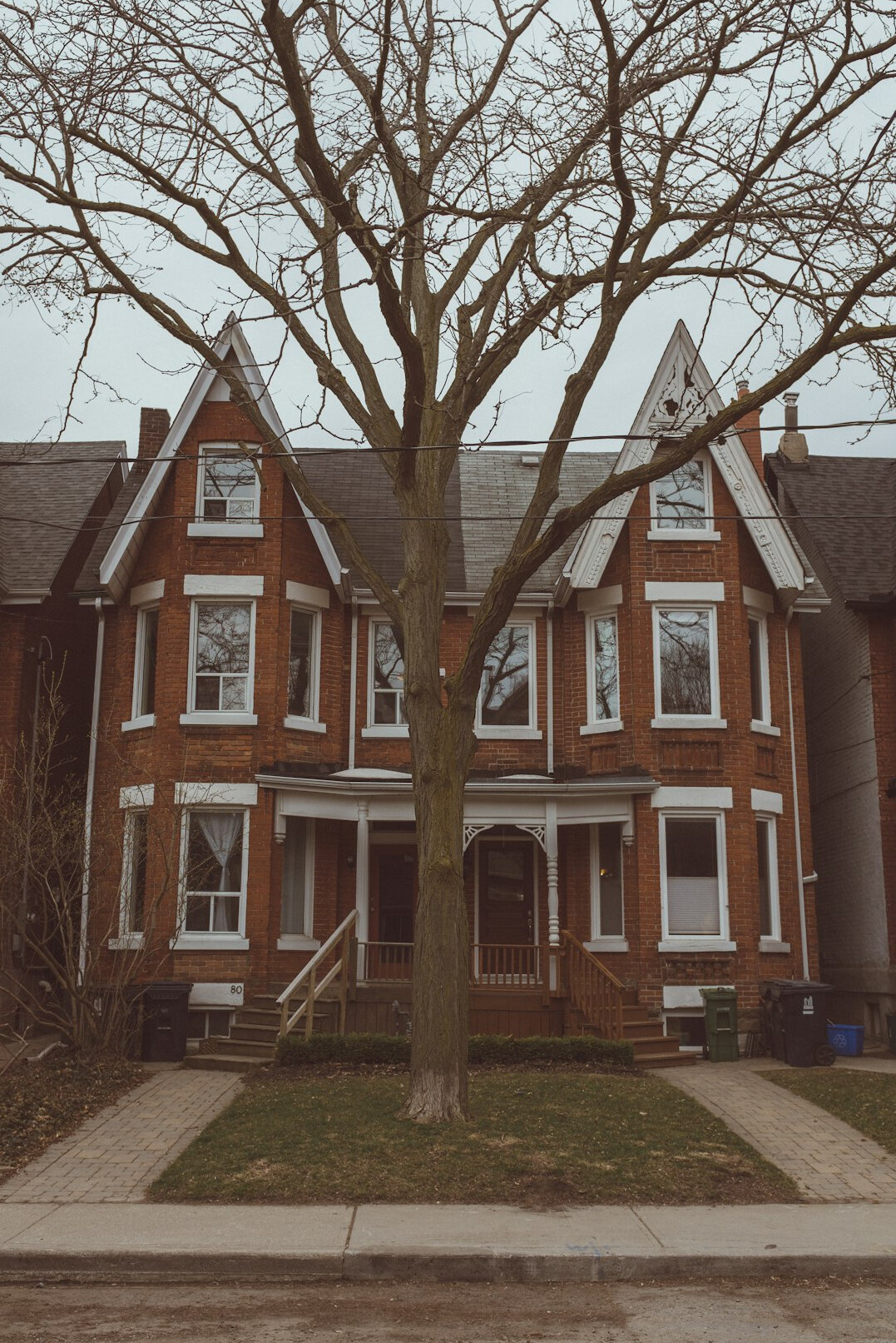 Heritage red brick rowhouses on a tree-lined Canadian street