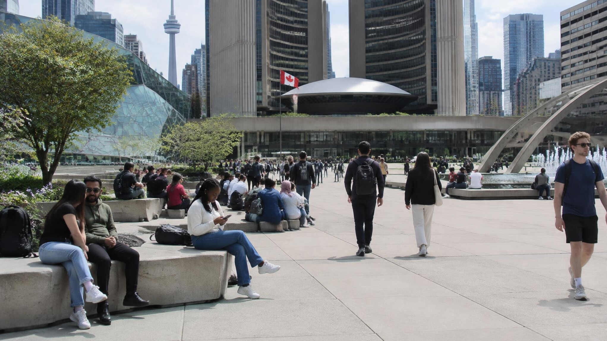 People walking through an open public plaza in a Canadian city